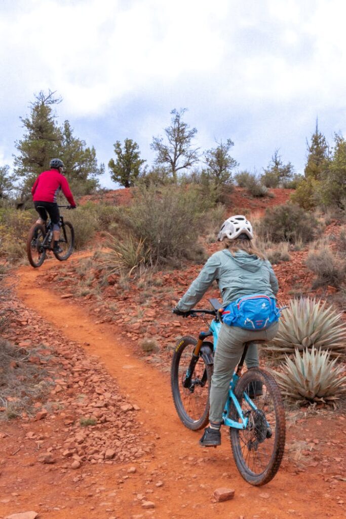 Two people riding bikes on a trail in the desert